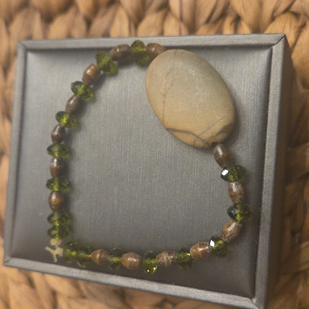 beaded bracelet with green peridot stones and a large, flat, polished
